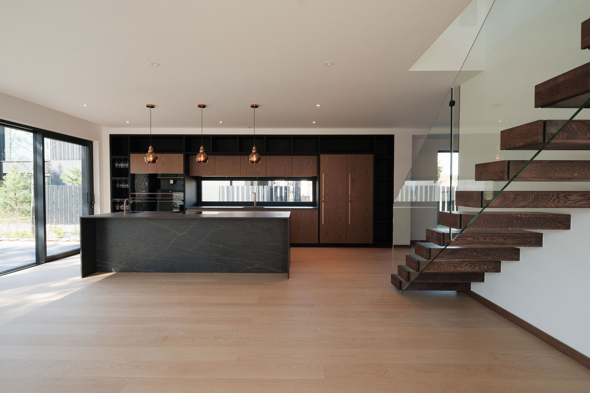 Innenraum einer MABUDO-Villa – Küche aus Stein, Nussbaum und Kupfer mit Treppe aus Eiche